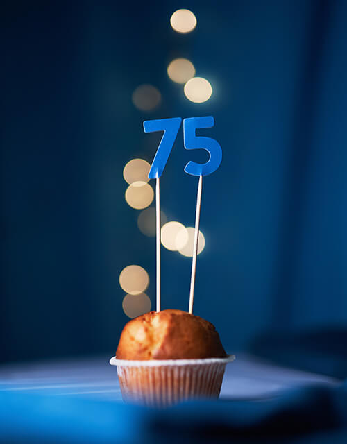 Cake topper with the number seventy five and blurred lights